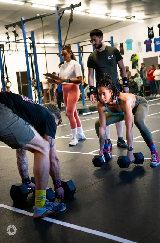 Pratiquants réalisant un exercice avec haltères pendant un cours collectif